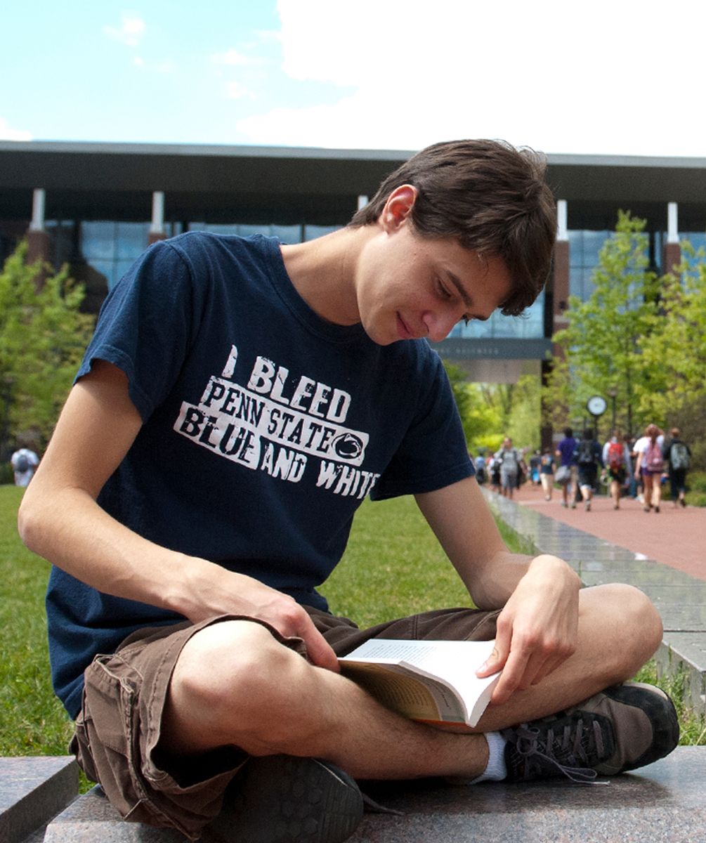 Penn State student studying outside in the Life Sciences Building.